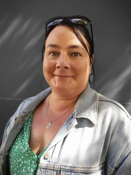Friendly woman smiling at Bell Block School, New Zealand, outdoor setting.