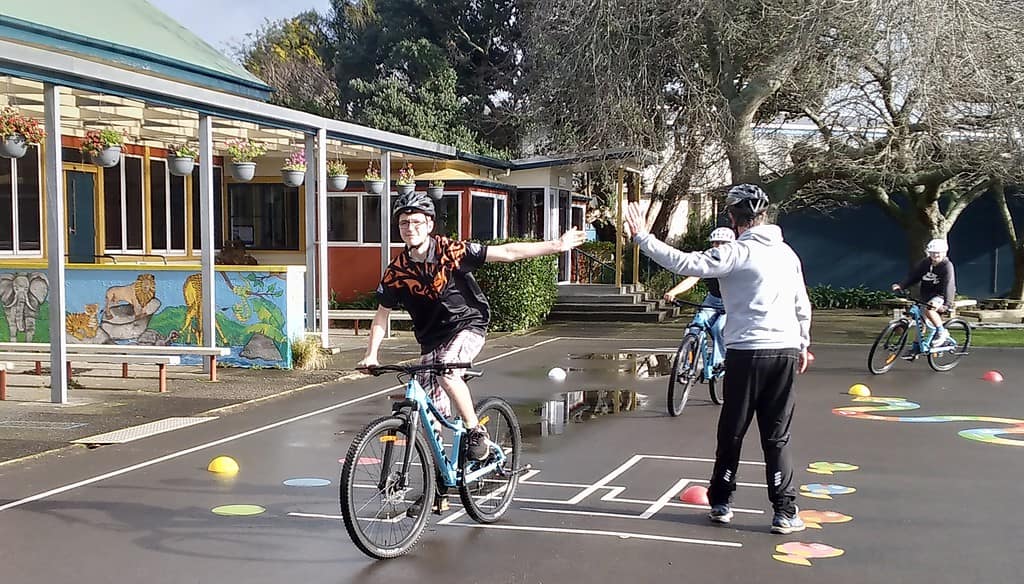Bike safety training at Bell Block School in New Zealand, kids learning cycling skills, outdoor school activity with helmets.