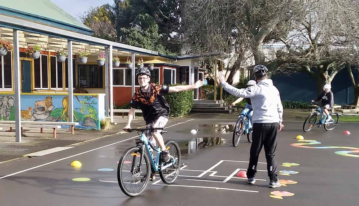 Bike safety training at Bell Block School in New Zealand, kids learning cycling skills, outdoor school activity with helmets.
