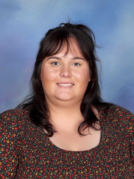 Hannah Purser, a staff member at Bell Block School, smiling in front of a blue background.