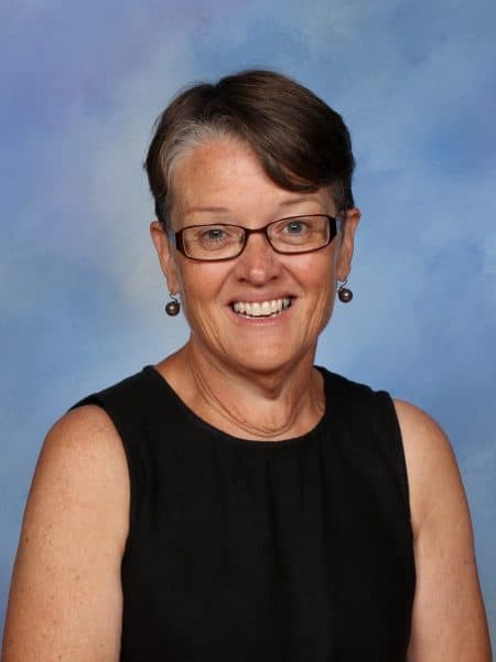 Bright, engaging portrait of a smiling teacher at Bell Block School, showcasing a friendly learning environment in New Zealand.