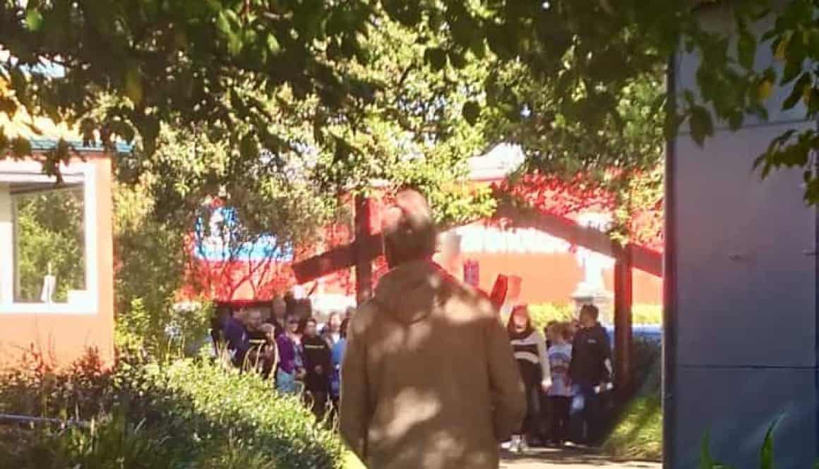Brightly lit pathway at Bell Block School with parents and students during school assembly.