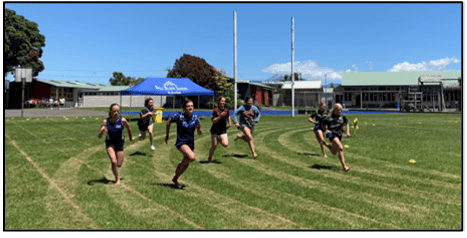 Students running on the sports field at Bell Block School, New Zealand, during a physical education class.