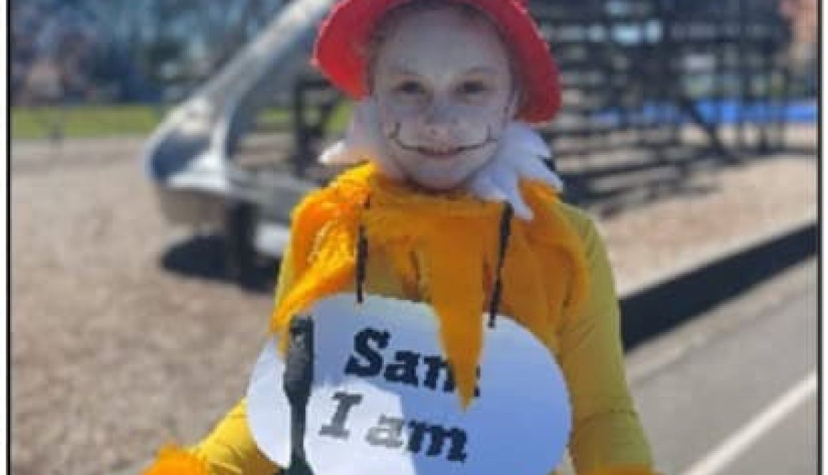 Bright young student dressed as a gnome for school event at Bell Block School, with playground in the background.