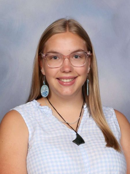 Bright young girl with glasses smiling for school photo at Bell Block School in New Zealand.