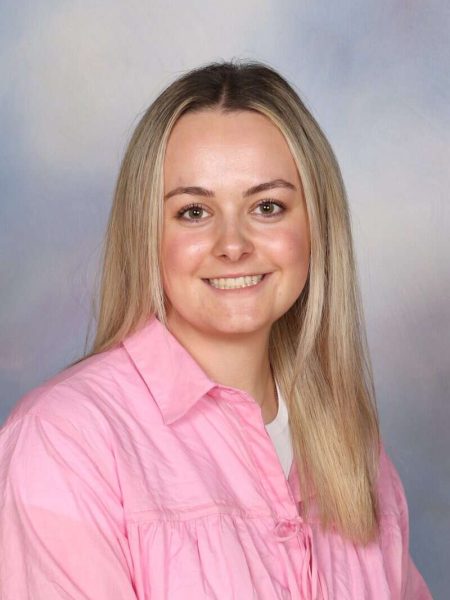 Smiling young woman in pink shirt, representing Bell Block School staff or community.