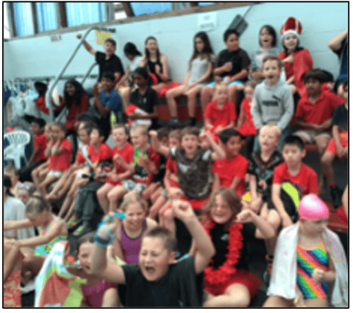 Swimming sports event at Bell Block School with students celebrating.