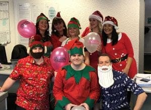 Festive staff in holiday costumes at Bennett Staff Christmas event.