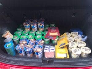 Grocery items including yogurts, sauces, and dairy products in the trunk.