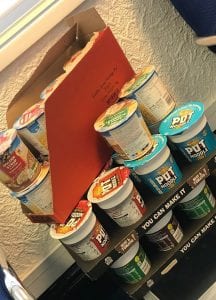 Assorted soup cans and boxes stacked on a shelf, ready for cooking.