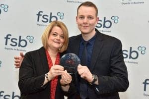 Two professionals holding an award at Bennett Staff event, smiling confidently.