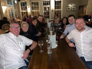 A group of colleagues enjoying a meal together in a warm, inviting atmosphere.