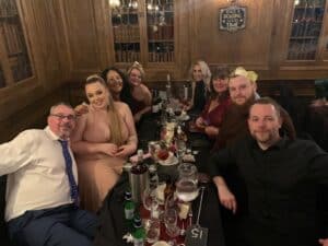 Celebrating team success at a corporate event in a traditional wood-paneled venue.