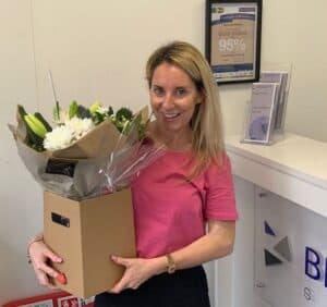 Woman holding a bouquet of flowers at Bennett Staff office.