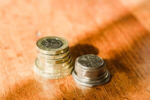 Stacked coins on a wooden surface representing minimum wage changes.