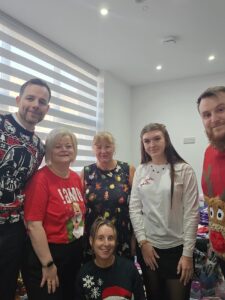 Group of diverse employees smiling in a modern office environment.