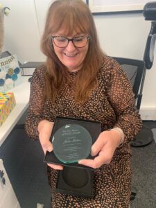 Dedicated staff member receiving recognition award.