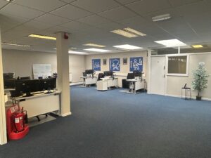 Bright office environment with workstations and accessibility signs.