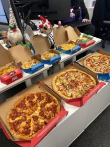 Group of pizza boxes and snacks on a table during a celebration.