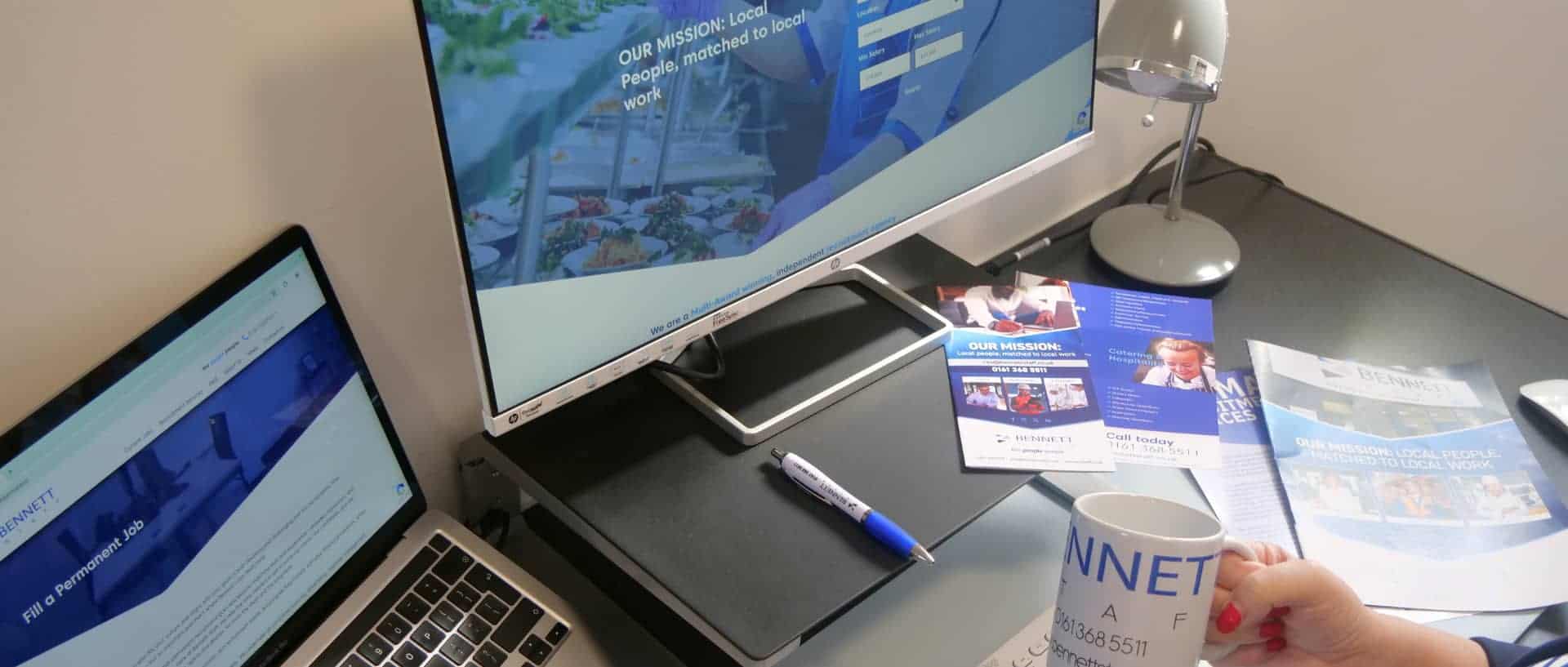 Office workspace with computer and printed materials for company history.