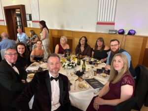 Celebrating the SME of the Year Award 2025 with a group of professionals at a formal event.