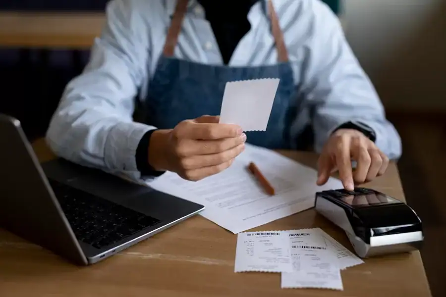 Receipt printing and payment processing with POS system and laptop in a modern retail environment.