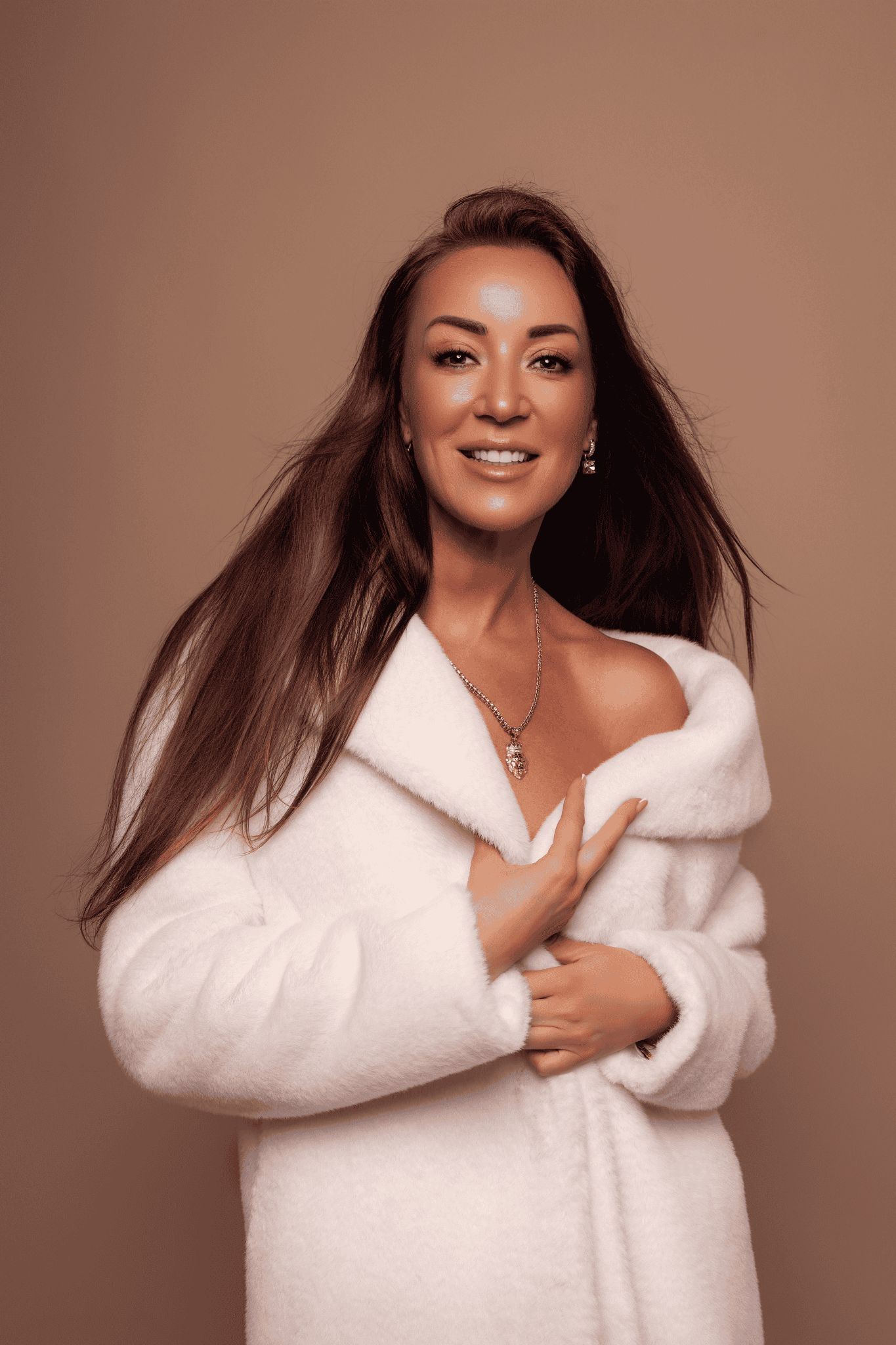 Elegant naine valges talvesituendis pildistatud stuudiokunstis.