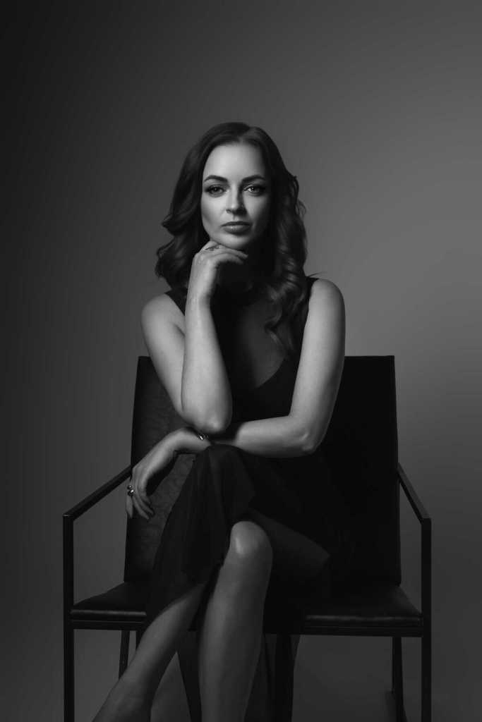 Portreefotosessioon stuudios toolil istuvast naisest.