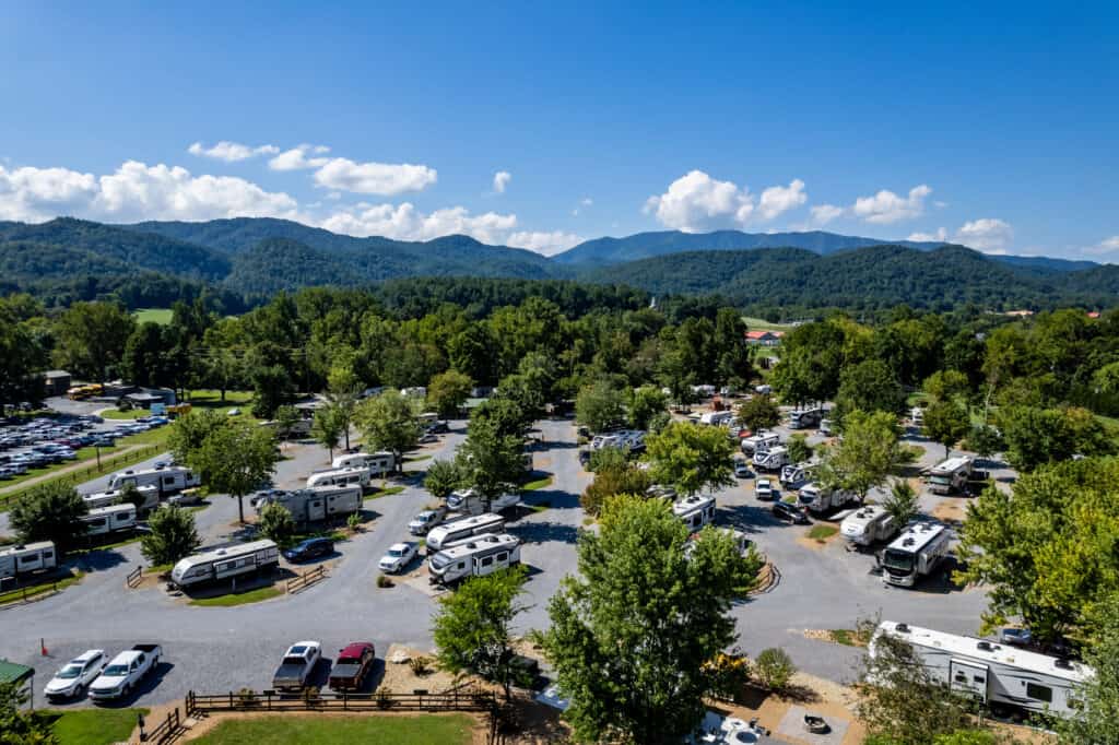 An aerial view of an rv park with mountains in the background.