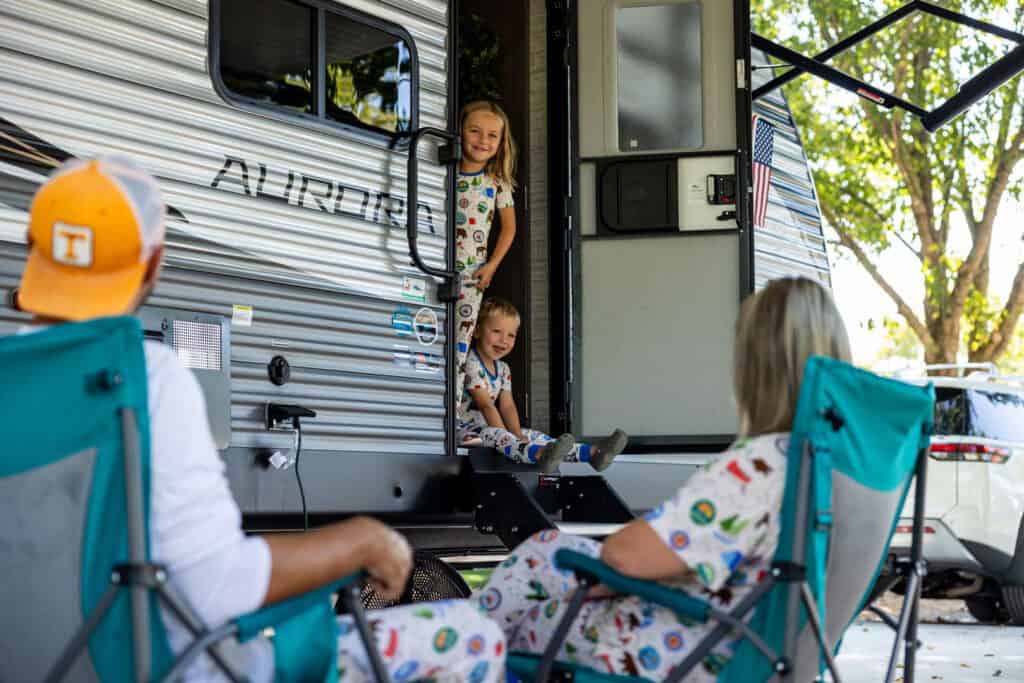A family sits in chairs outside of an RV at the Big Meadows Campground.