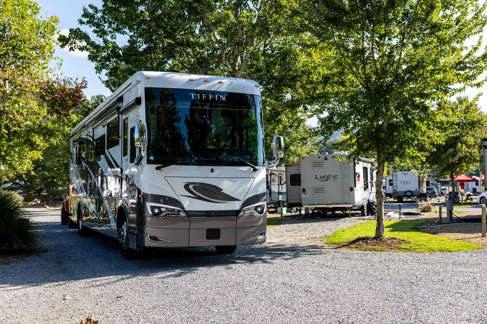 A white rv parked in a gravel lot.