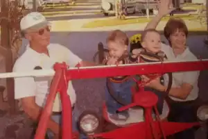 A man and woman with a baby in a red tractor.