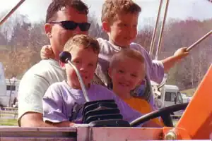 A man and two boys sitting in a car.