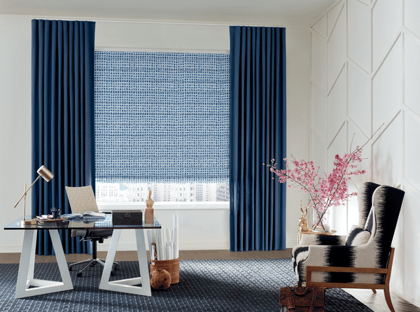 Stylish blue roller blackout blinds with elegant curtains for modern home decor.