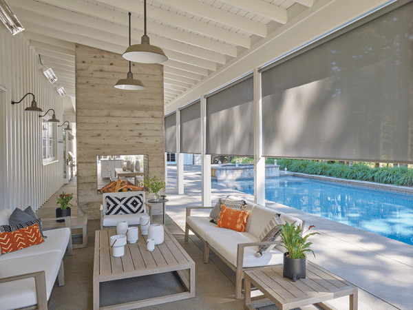 Bright indoor-outdoor patio with modern furniture, large windows, and a swimming pool for relaxing outdoor living.