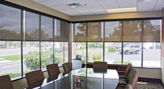 Modern conference room with large windows and meeting table for business discussions.