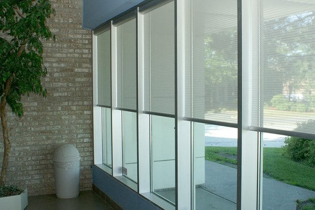 Textile roller shades for windows in commercial space.