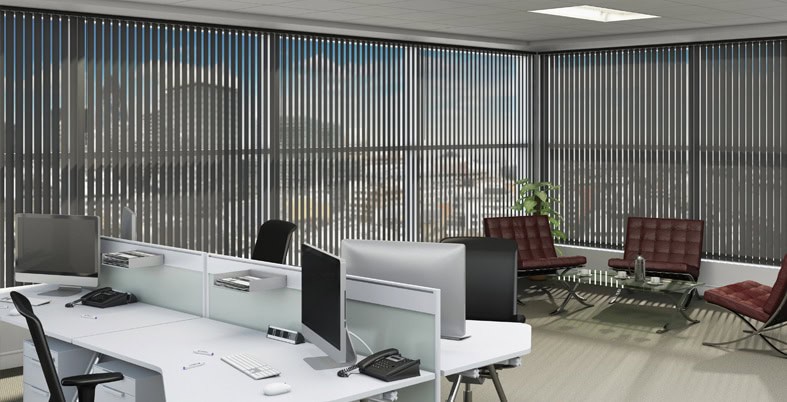 Modern office workspace with call desks and comfortable seating, bright natural light from large window blinds.