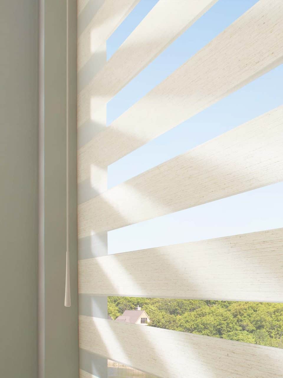 Modern beige window blinds with sunlight streaming through, offering privacy and light control.