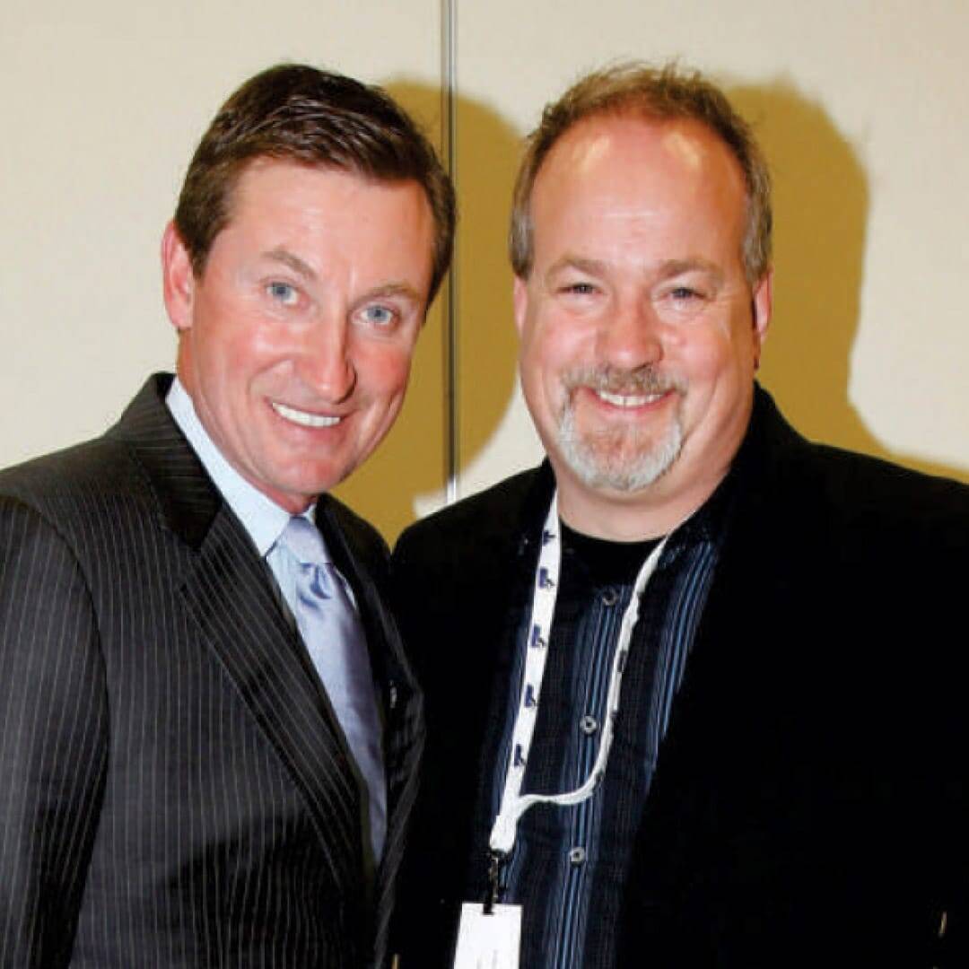 Loving group photo of two professional men smiling at an event.
