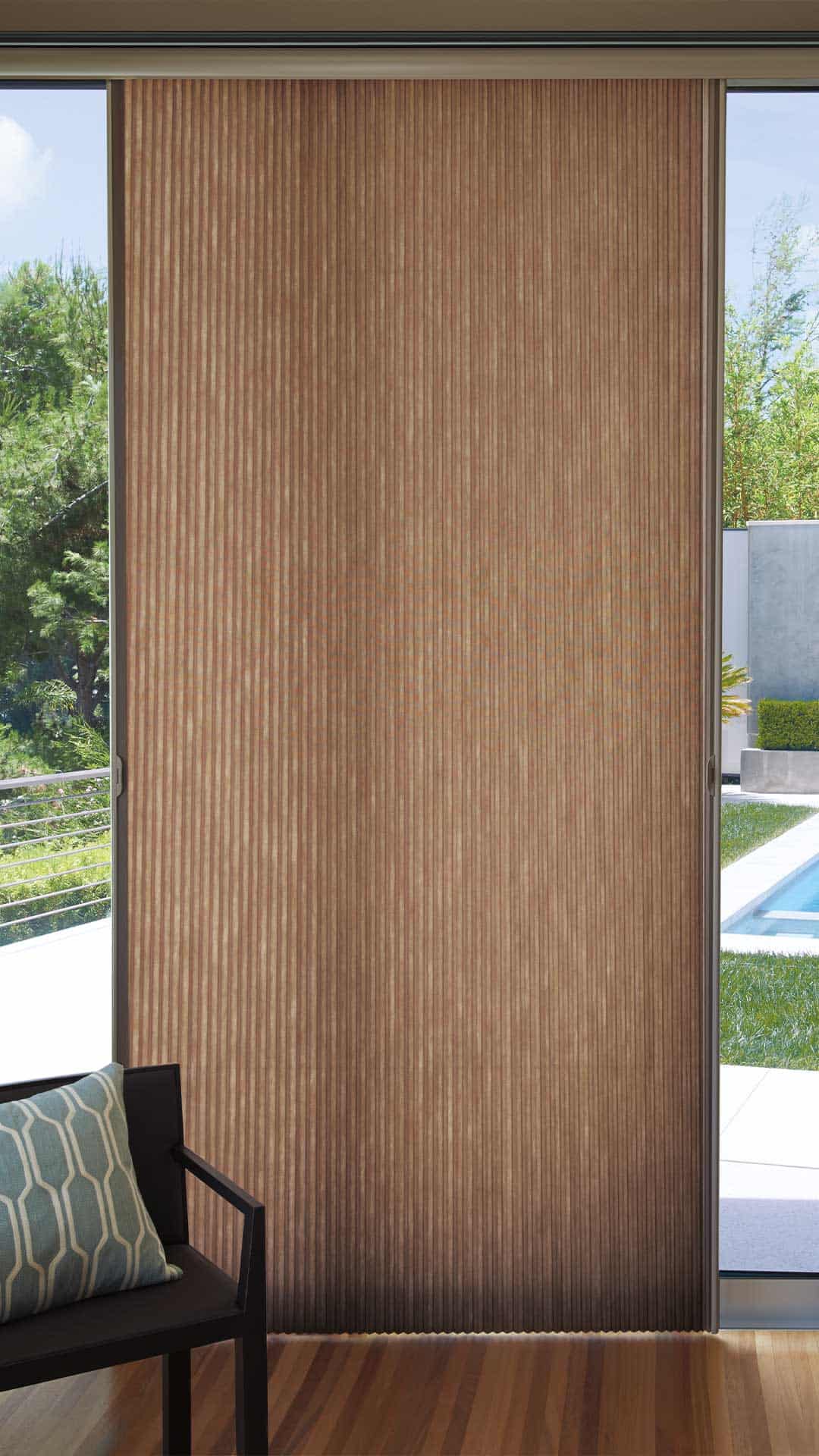 Smooth wooden sliding door with vertical slats near a glass window, demonstrating modern interior design.