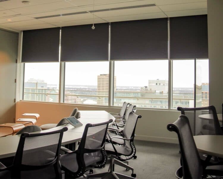 Modern office conference room with city view and window blinds, suitable for meetings and presentations.