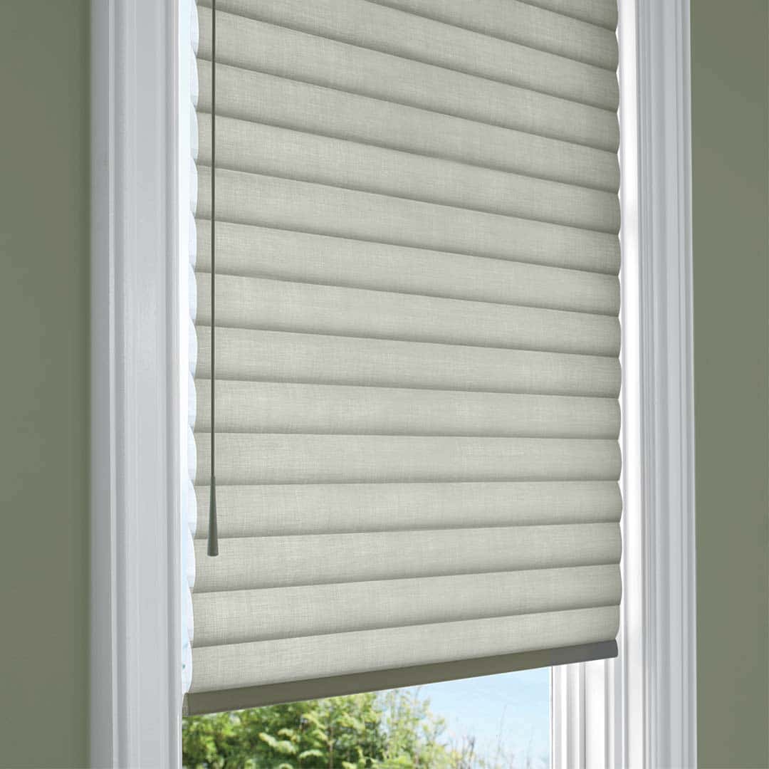 Smooth beige pleated window blind for privacy and light control.