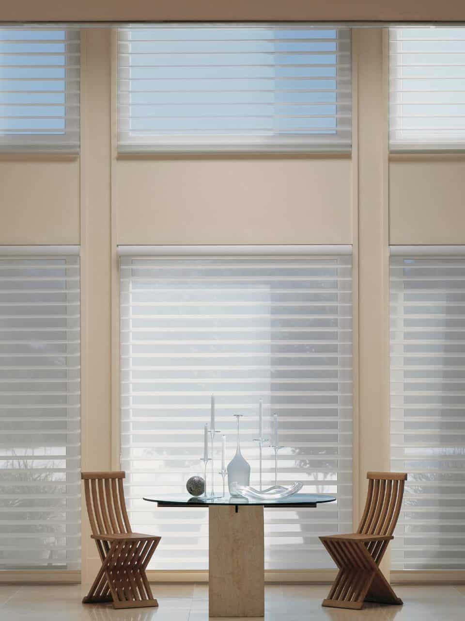 Bright modern window blinds with a cozy dining area featuring wooden chairs and a glass table.