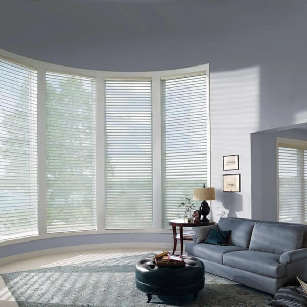 Light-filtering horizontal blinds on large bay windows in a modern living room, providing privacy and controlling natural sunlight.