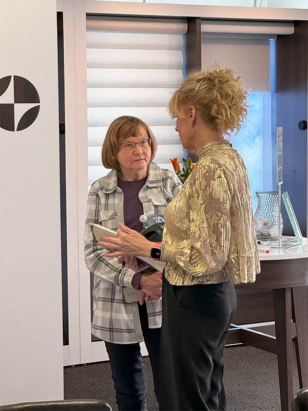 She and a woman having a conversation in an indoor setting.