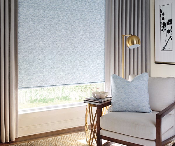 Blue window roller blind in modern living room, stylish shade for light control and privacy.
