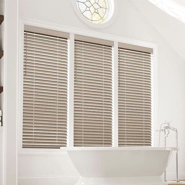 Elegant window blinds in a modern bathroom, featuring white window frame, natural light, and a decorative stained glass round window, creating a serene and stylish ambiance.