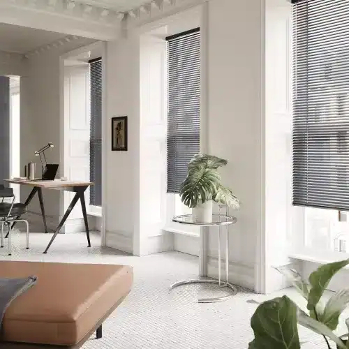 Spacious home workspace with bright natural light, black window blinds, and contemporary decor for productivity and comfort.