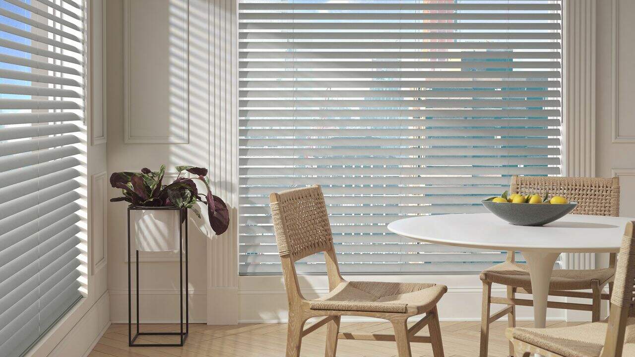 Bright interior with natural light filtering through horizontal blinds and stylish furniture.